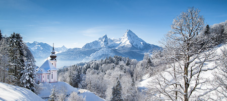 Panoramic view of beautiful winter wonderland mountain scenery in the Alps with pilgrimage church of Maria Gern and famous Watzmann summit in the background, Berchtesgadener Land, Bavaria, Germanyの写真素材