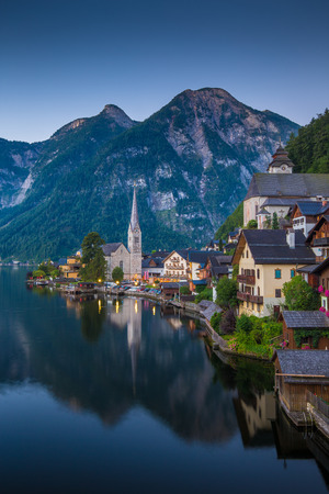 Scenic picture-postcard view of famous historic Hallstatt mountain village with Hallstattersee in the Austrian Alps in mystic twilight during blue hour at dawn in summer, Salzkammergut region, Austriaの写真素材
