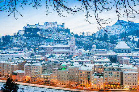 Classic view of the historic city of Salzburg with Salzburg Cathedral and famous Festung Hohensalzburg illuminated in beautiful twilight during Christmas time in winter, Salzburger Land, Austriaの写真素材