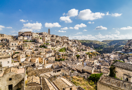 Ancient town of Matera (Sassi di Matera), European Capital of Culture 2019, in beautiful golden morning light at sunrise with blue sky and clouds, Basilicata, southern Italyの写真素材