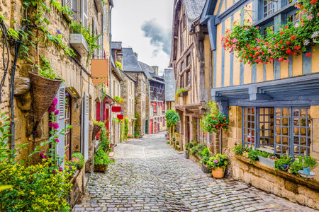 Beautiful view of scenic narrow alley with historic traditional houses and cobbled street in an old town in Europe with blue sky and clouds in summer with retro vintage grunge filter effectの写真素材