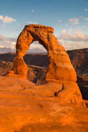 Classic postcard view of famous Delicate Arch, symbol of Utah and a popular scenic tourist attraction, in beautiful golden evening light at sunset in summer, Arches National Park, Moab, Utah, USAの写真素材