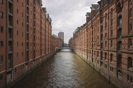 Classic panoramic view of famous Speicherstadt warehouse district with dark moody clouds before the storm with retro vintage style filter effect, Hamburg, Germanyの写真素材