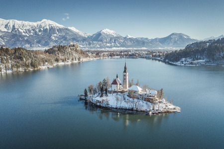 Panoramic view of famous Bled Island (Blejski otok) at scenic Lake Bled with Bled Castle (Blejski grad) and Julian Alps in the background on a beautiful sunny day in winter, Sloveniaのeditorial素材
