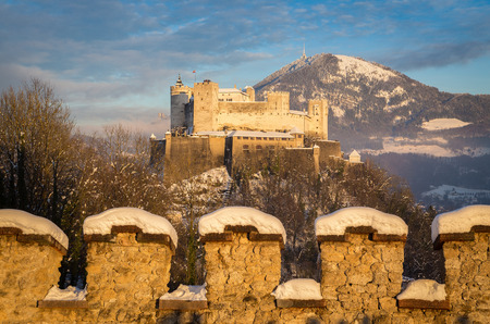 Classic view of famous Festung Hohensalzburg in the historic city of Salzburg illuminated in beautiful golden evening light with blue sky during Christmas time in winter, Salzburger Land, Austriaの写真素材