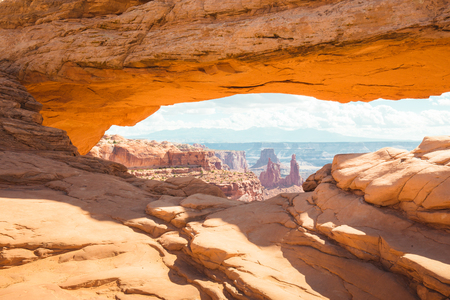 Classic view of famous Mesa Arch, symbol of the American West, illuminated in scenic golden morning lightの写真素材