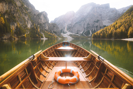 Beautiful view of traditional wooden rowing boat on scenic Lago di Braies in the Dolomites in scenic morning lightの写真素材