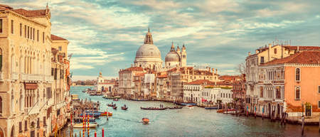 Classic panoramic view of famous Canal Grande with scenic Basilica di Santa Maria della Salute in beautiful golden eveningの写真素材