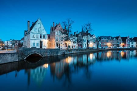Beautiful twilight view of the historic city center of Brugge with old houses along famous Potterierei canal illuminated during blue hour at dusk, Brugge, Flanders region, Belgiumの写真素材