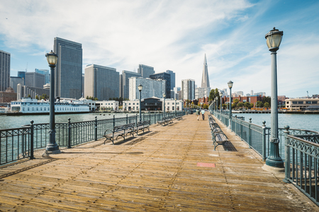 Classic view of historic Pier 7 with the modern financial district of San Francisco on a beautiful sunny day with blue sky and clouds in summer, California, USAの写真素材