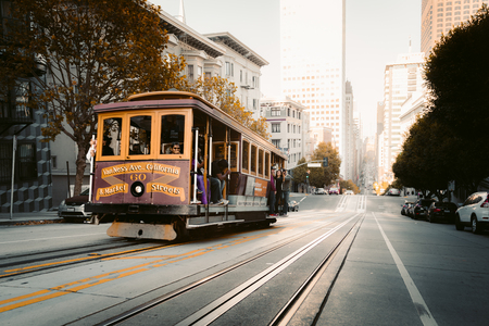 Historic Cable Car riding on famous California Street in beautiful golden evening light at sunset, San Francisco, California, USAの写真素材
