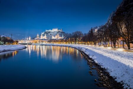 Classic view of the historic city of Salzburg with famous Festung Hohensalzburg and Salzach river illuminated in beautiful twilight during scenic Christmas time in winter, Salzburger Land, Austriaの写真素材