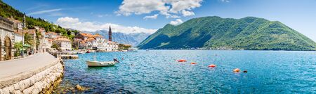 Classic panorama view of the historic town of Perast located at world-famous Bay of Kotor on a beautiful sunny day with blue sky and clouds in summer, Montenegro, southern Europe.の写真素材
