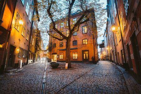 Charming Stockholm street scene with old colorful houses in beautiful golden evening light at sunset in Gamla Stan Old Town district, Swedenの写真素材
