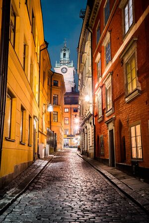 Classic twilight view of tradtional houses in beautiful alleyway in Stockholm's historic Gamla Stan (Old Town) illuminated during blue hour at dusk, central Stockholm, Swedenの写真素材