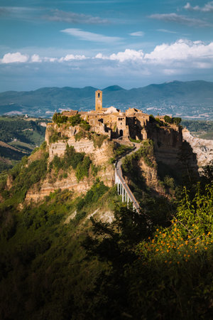 Beautiful view of famous Civita di Bagnoregio with Tiber river valley and dramatic cloudscape at sunset, Lazio, Italyの写真素材