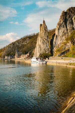 Panoramic view of scenic Meuse river with famous Bayard Rock and the historic town of Dinant in the background in beautiful golden evening light at sunset in spring, Wallonia, Belgiumの写真素材
