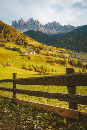 Beautiful view of idyllic mountain scenery in the Dolomites with famous Santa Maddelana mountain village in beautiful golden evening light at sunset in fall, Val di Funes, South Tyrol, northern Italy.の写真素材
