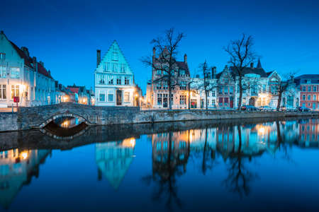 Beautiful twilight view of the historic city center of Brugge with old houses along famous Potterierei canal illuminated during blue hour at dusk, Brugge, Flanders region, Belgiumのeditorial素材