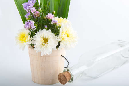 Colorful flowers in the wooden bucket on the white backgroundの写真素材