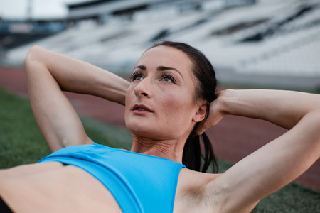 Professional female trainer showing exercise in a stadiumの写真素材