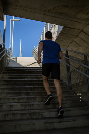 Male runner climbing up the stairs with easeの写真素材