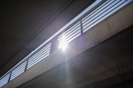Male athlete running on a bridge, urban scenety,  viewed from below