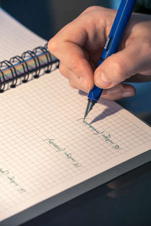 hand with a fountain pen making notes on a calendarの写真素材