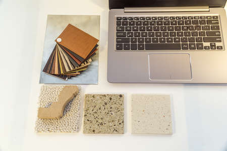 laptop lying on the desk and next to it samples, fabrics, veneers, wood, stoneの写真素材