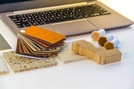 laptop lying on the desk and next to it samples, fabrics, veneers, wood, stoneの写真素材