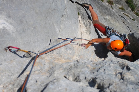 Rock climbing. Young woman climbing a limestone rockの写真素材
