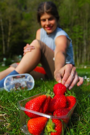Young woman grabbing for fresh strawberryの写真素材