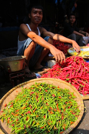 BOGOR, INDONESIA - JULY 4: Man selling chilli peppers on a market on July 4, 2011 in Bogor, Indonesiaのeditorial素材