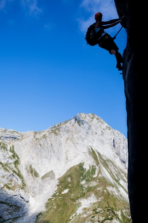 Silhouette of a climber above mountain peaksの写真素材