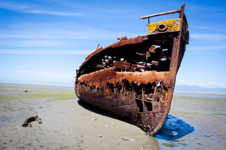 Rusty old shipwreck trapped on a beach.の写真素材