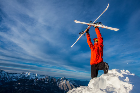Young man posing with freeride ski on a mountain summitの写真素材