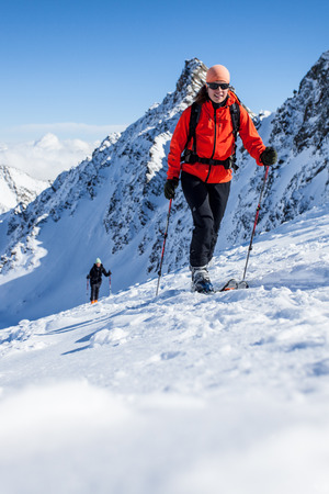 Young woman with ski in winter mountainsの写真素材
