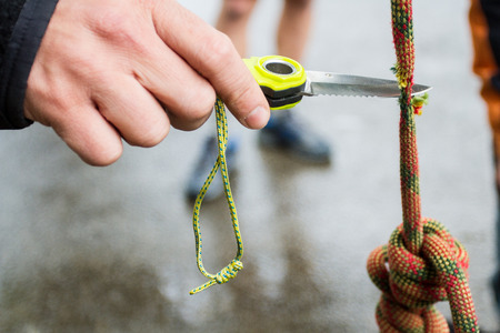 Hand with knife cutting the ropeの写真素材