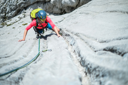Young woman climbing limestone faceの写真素材