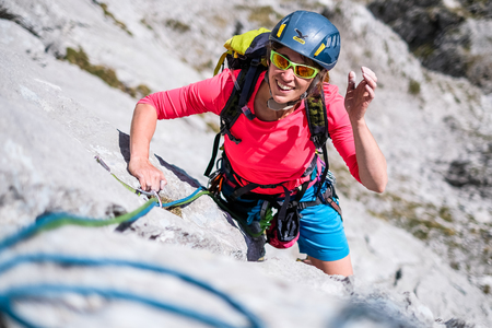 Young woman having fun during rock climbing ascentの写真素材