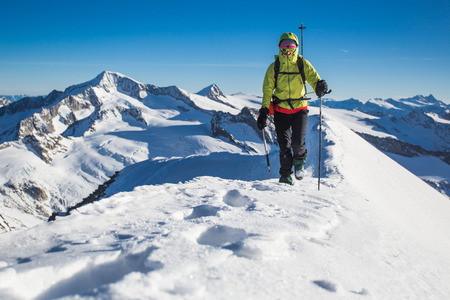 Young woman climbing snow ridge in the Alpsの写真素材