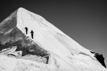 Two climbers on the glacial summit ridge