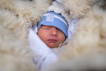 Portrait of a small baby sleeping outside in winter