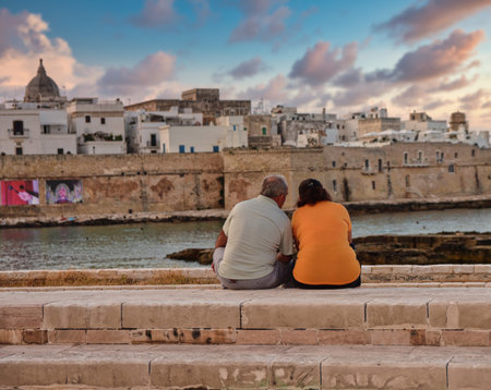 Old couple relaxing together near the Italian sea in the Puglia religion