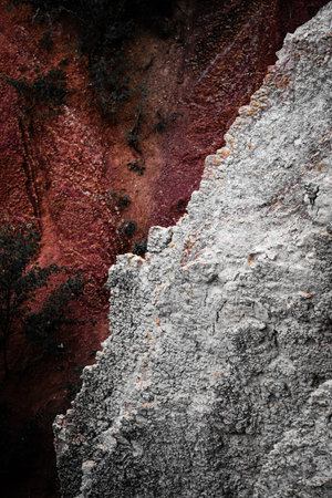 Textured rock surface with red and gray tones, natural stone detail in Prokop Valley, Prague.
