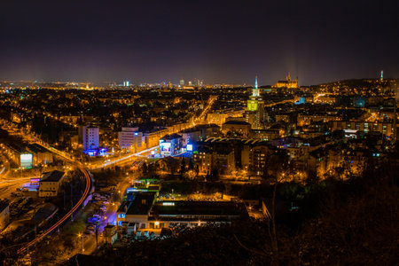 Scenic night view of Prague, with illuminated city streets, modern buildings, and Prague Castle in the distance.の写真素材