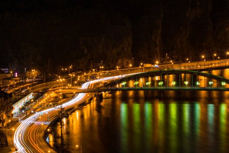 Night view of UstÃ­ nad Labem, featuring car light trails and the illuminated railway station along the Elbe River.の写真素材