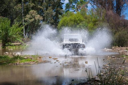 Rural Andalucia. Spain. 06/10/2016. Riverbed crossing in 4x4 terrain vehicle on speed with water splashing.の写真素材