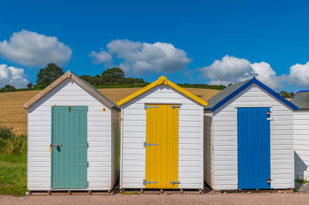 Colourful beach houses. Row of multicolored beach huts against blue sky.の写真素材