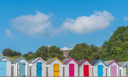 Colourful beach houses. Row of multicolored beach huts against blue sky.の写真素材